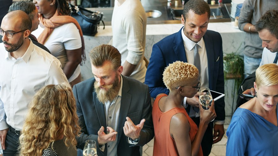 A diverse group of guests standing in conversation at a mixer