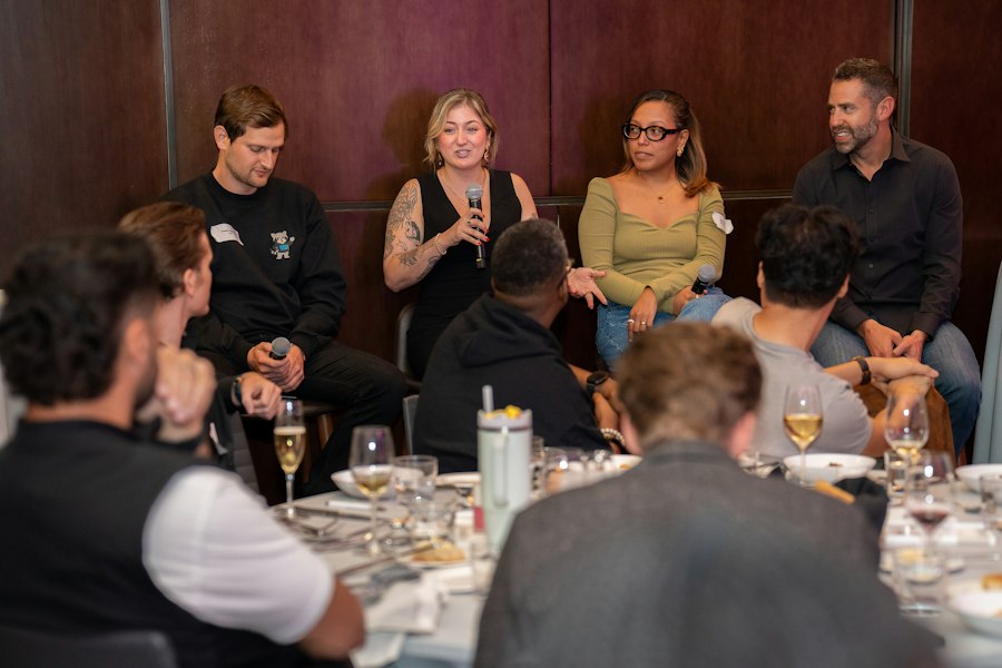Panel speakers talking with an audience seated at tables